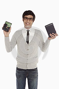 Man holding up an external hard disc