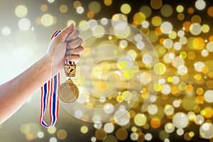 Man holding up a gold medal against,win concept.