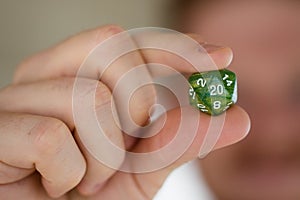 Man Holding Up Green Polyhedral Dice Dungeons and Dragons