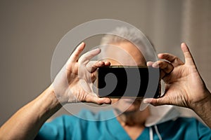 Man holding up his smartphone to hide his identity and keep privacy