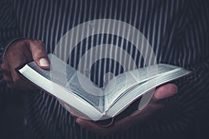 Man holding up an open Bible in his hands