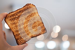 Man holding up a toast was burnt during toasting