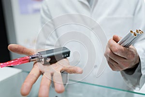 Man holding vaporizer and conventional tobacco cigarettes