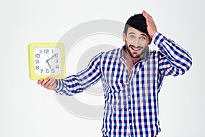 Man holding wall clock and looking at camera