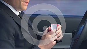 Man holding wedding ring hesitating to marry, scared of family responsibilities