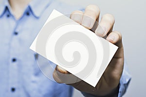 Man holding white business card on concrete wall background,mockup template