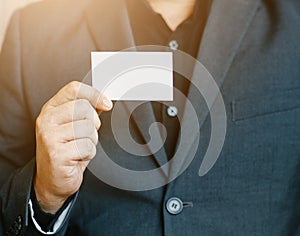 Man holding white business card,Man wearing blue shirt and showing blank white business card. Blurred background. Horizontal mocku