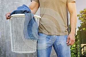 Man holding a white laundry hamper