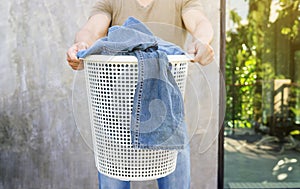 Man holding a white laundry hamper