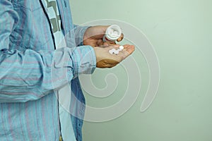 Man holding White pills and medicine bottles, paracetamol, Headache medicine Vitamin And Dietary Supplements