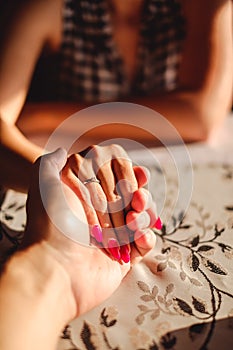 Man holding woman`s hand with engagement ring on the finger