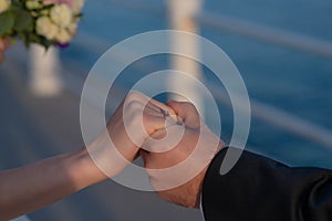 Man holding woman`s hand in a romantic gesture, close-up on hands and engagement diamond ring, beautiful couple getting married