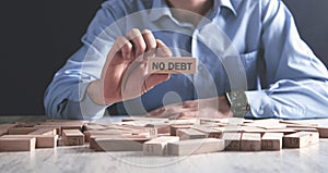 Man holding wooden block. No Debt