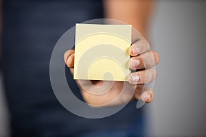 Man holding a yellow sticky note