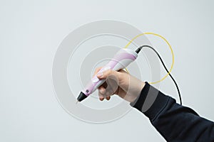 A man holds a 3d pen in his hand. 3d pen in a man`s hand. Drawing technological plastic handle.