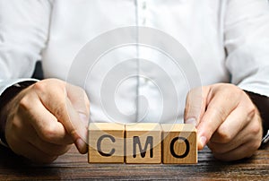 Man holds abbreviation CMO. Marketing strategy of the company. Post top manager Chief Marketing Officer. PR and advertising photo