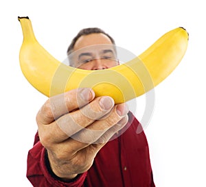 Man holds banana in front of his face