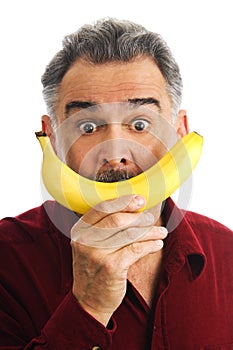 Man holds banana to face, imitating smile