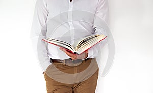 A man holds a big red book in his hands.