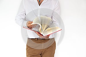 A man holds a big red book in his hands.