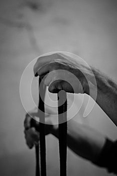 A man holds black shibari ropes in his hand