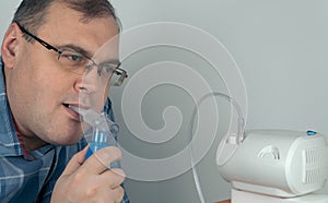 Man holds a breathing mask and inhales. nebulizer and Oxygen Mask. spraying of a drug that is delivered to the patient through a