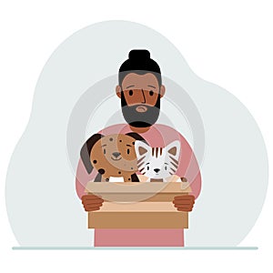 A man holds a cardboard box with a cat and a dog. The concept of rescue, help and care for pets.