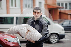 A man holds a child wrapped in a blanket. Father holding his son in his arms