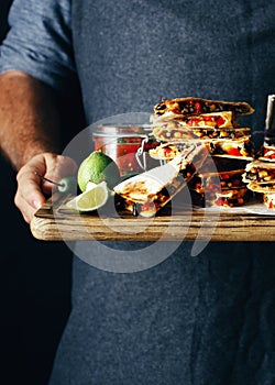 Man holds cutting board snack beer quesadilla lager beer