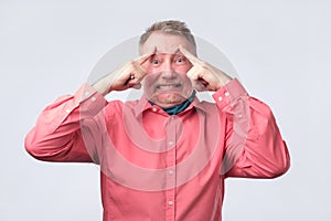 Man holds fingers on temples, trying to remember