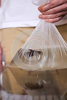 A man holds a fish in a plastic bag close-up