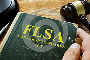 Man holds FLSA fair labor standards act book photo