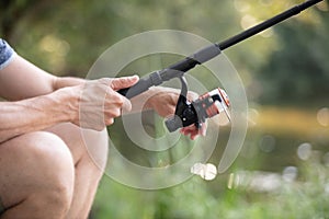 man holds fly rod with one hand