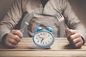 Man holds fork with knife. Time to eat.