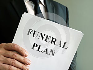 Man holds Funeral plan and stack of papers