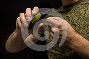 A man holds a grenade in his hand and pulls the pin, wants to detonate a grenade.