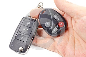 Man holds in hand ignition key and garage door remote control