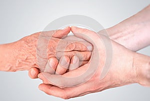 Man holds hands of eldery woman. Senior help and assistance concept.
