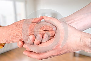 Man holds hands of eldery woman. Senior help and assistance concept photo