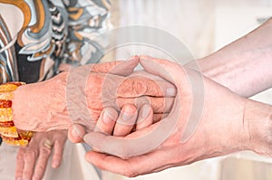 Man holds hands of eldery woman. Senior help concept