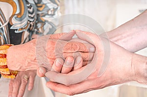 Man holds hands of eldery woman. Senior help concept photo