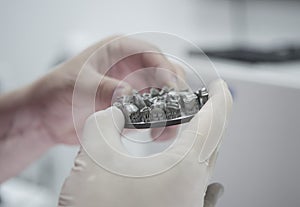 Man holds in hands object printed on metal 3d printer in laboratory.