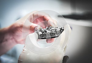 Man holds in hands object printed on metal 3d printer in laboratory.