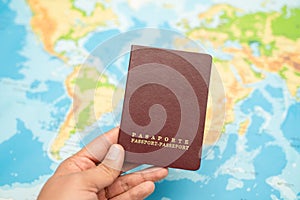 Man holds with his hand the Passport, world map. Travel concept