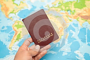 Man holds with his hand the Passport, world map. Travel concept