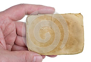 A man holds in his hand a sheet of yellowed old paper from an ancient notebook isolated