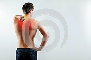 A man holds his hands for a damaged shoulder, a pain in his shoulder highlighted in red.