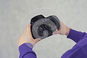 Man holds in his hands glasses for virtual reality and 360-degree video. VR helmet for the smartphone on a light background