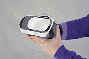 Man holds in his hands glasses for virtual reality and 360-degree video. VR helmet for the smartphone on a light background