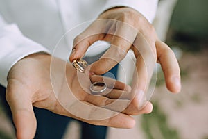 A man holds in his hands on the palms of the wedding gold rings. Close-up